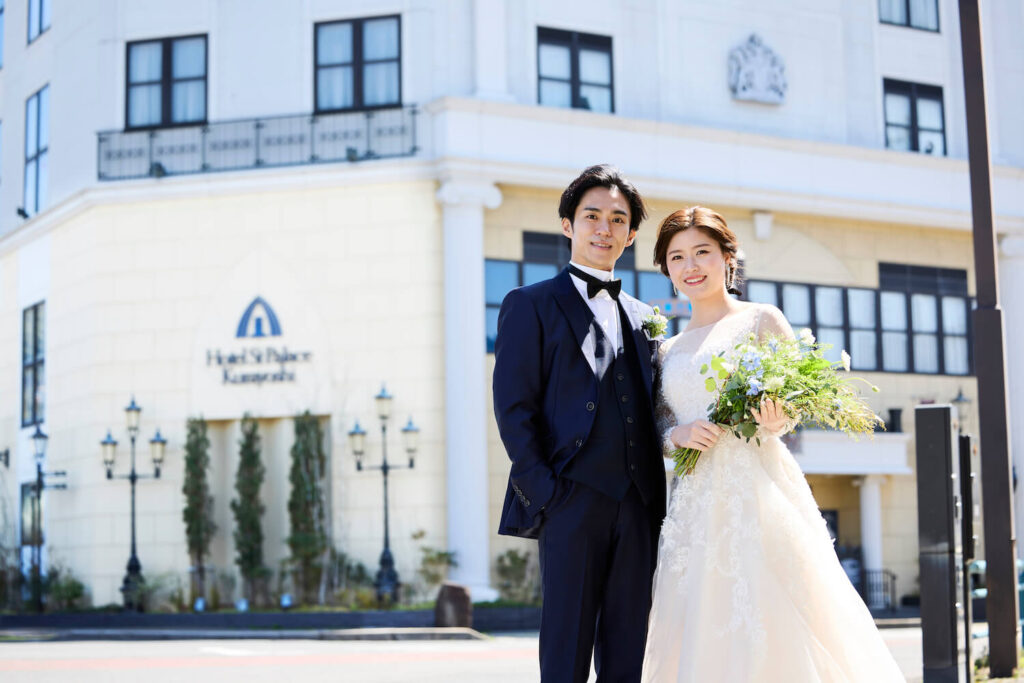 鳥取県の結婚式場 ホテルセントパレス倉吉ウェディングをバックに記念写真を取る新郎新婦